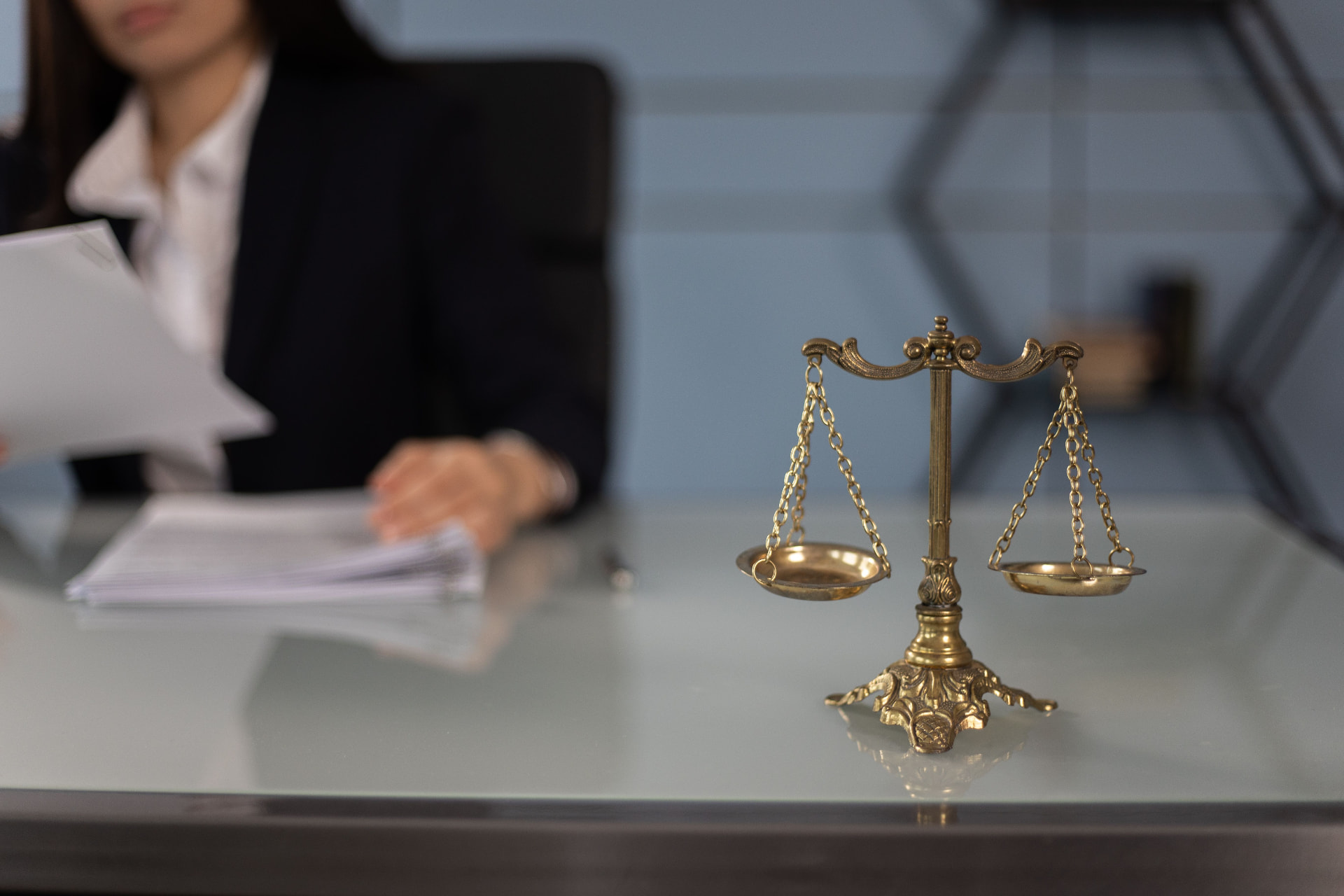 Lawyer reviewing contract documents beside a brass balance scale